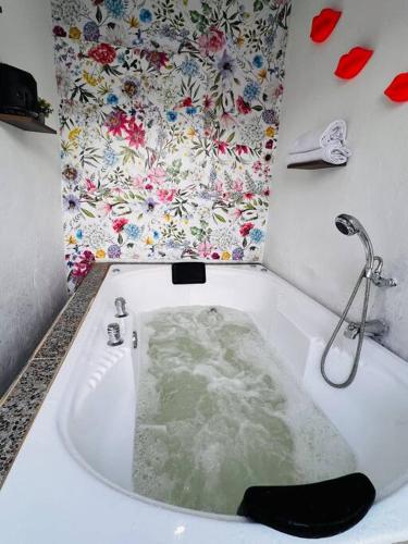 a bath tub filled with water in a bathroom at Serenity House Casa Huaxtla del Arenal in Huastla