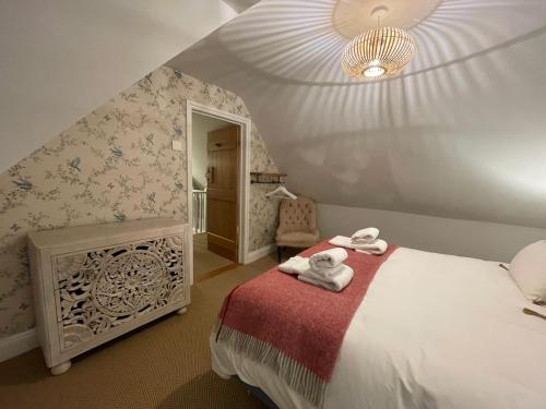 a bedroom with a bed with towels on it at Cottage 7 mins from Henley with gated parking in Henley on Thames