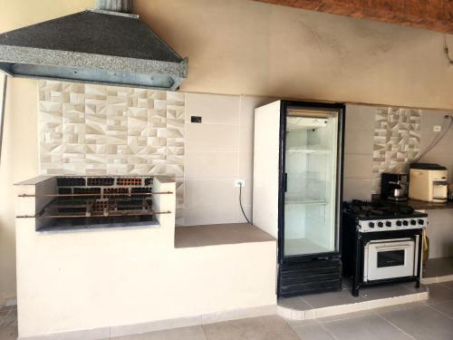 a kitchen with a stove and a refrigerator at Casa Ampla e confortável in São Sebastião