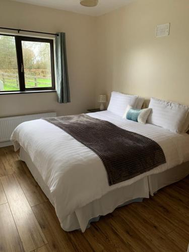 Schlafzimmer mit einem großen weißen Bett und einem Fenster in der Unterkunft Kits Lodge Crover in Cavan