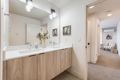 a bathroom with two sinks and a large mirror at View on Franklin BY Betterstay in Seattle