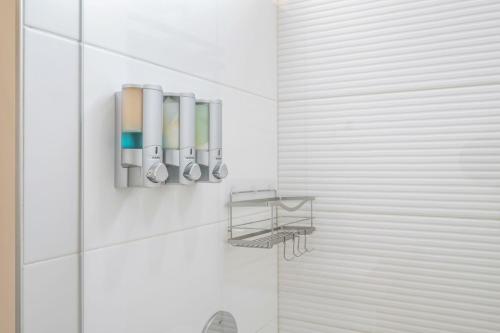 a bathroom with a shower with toothbrushes on the wall at Modern & Cozy New Townhome; Heart of Fremont in Seattle
