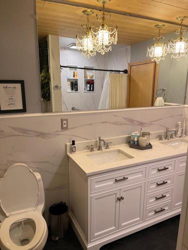 a bathroom with a sink and a toilet and a mirror at Cheerful, sun-kissed room with workstation in Revere