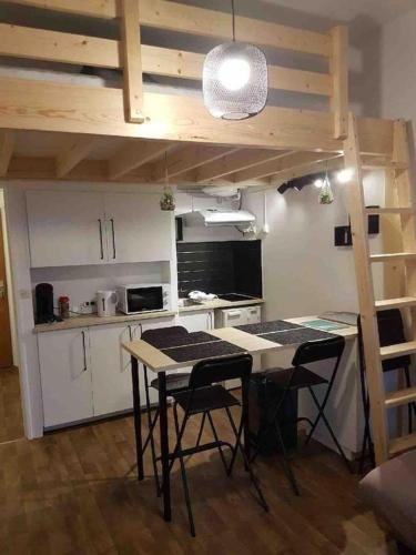 une cuisine avec une table et des chaises dans une pièce dans l'établissement Studio à la plage, à Donville-les-Bains