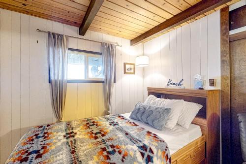 1 dormitorio con cama con edredón y ventana en Eagles' Oceanview en Sequim