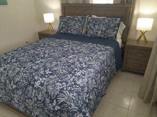 a bedroom with a blue and white bed with two lamps at Apt 1 Lynsted - Newly renovated 2 bed 1 bath in Bridgetown