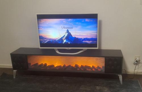 TV de pantalla plana con chimenea en Queen Home en Luzern