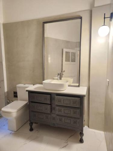 a bathroom with a sink and a toilet and a mirror at Baires Art Decó in Buenos Aires