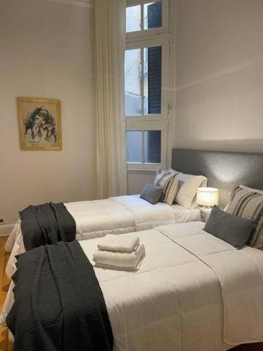 two white beds in a room with a window at Baires Art Decó in Buenos Aires