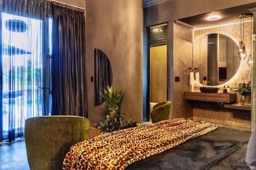 a bedroom with a bed and a sink and a mirror at Hotel Osvé Boutique Cali in Cali