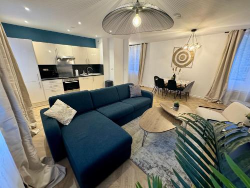 un salon avec un canapé bleu et une table dans l'établissement L'escale Versaillaise, à Saint-Cyr-lʼÉcole