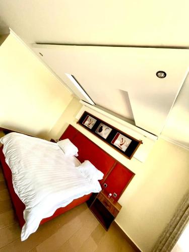 a bedroom with a bed with white sheets and a red headboard at Contemporary Suite in Kibuye