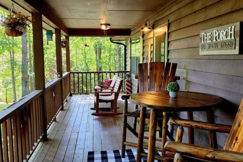 a porch with a wooden table and chairs on it at Woods Upon a Time Remodeled Cabin with Fireplace, Pond View & Firepit - Your Getaway Story Awaits! in Murphy