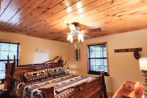 a bedroom with a bed with a wooden ceiling at Woods Upon a Time Remodeled Cabin with Fireplace, Pond View & Firepit - Your Getaway Story Awaits! in Murphy