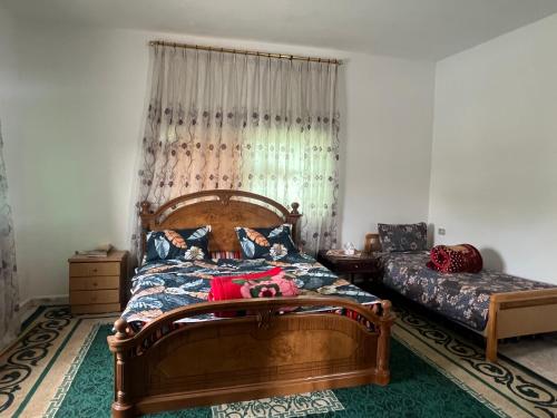 a bedroom with a wooden bed and a window at Abuawad Rental in Jerash