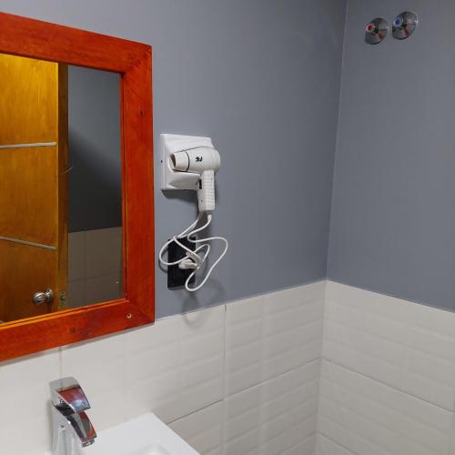 a bathroom with a soap dispenser on the wall at Hotel Segundo Roma in Villa La Paz