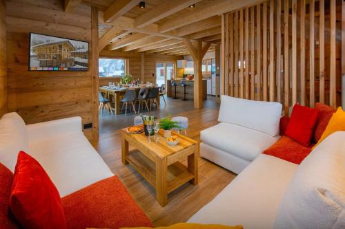 un salon avec des canapés blancs et une table dans l'établissement Chalet Trusquin - OVO Network, au Grand-Bornand
