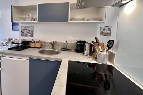uma cozinha com um lavatório e uma bancada em Le studio du port by Póm em Lorient