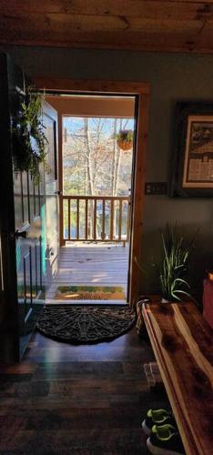 an open door of a house with a porch at Woods Upon a Time Remodeled Cabin with Fireplace, Pond View & Firepit - Your Getaway Story Awaits! in Murphy