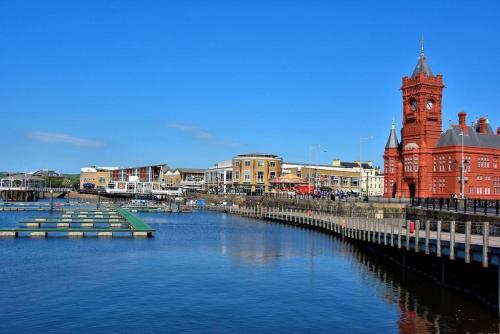 a city with a river and a clock tower at 1 Bed Apartment in Cardiff Bay -Dixie Buildings in Cardiff