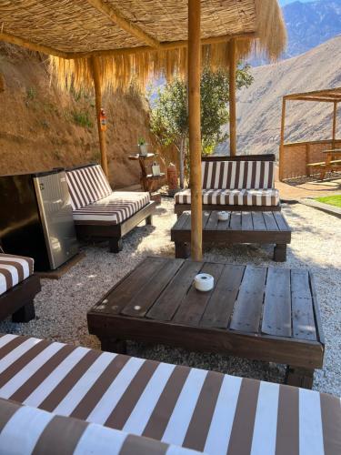 un patio con sofás y una mesa de madera con en Cabañas Miraelqui, en Pisco Elqui