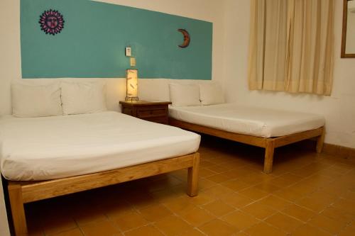 two beds sitting in a room withermottermott at Hotel San Lorenzo in Barra de Navidad