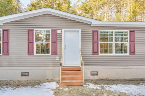 a gray house with red windows and a white door at Less Than 1 Mi to Beach Peaceful Brant Lake Home! in Brant Lake