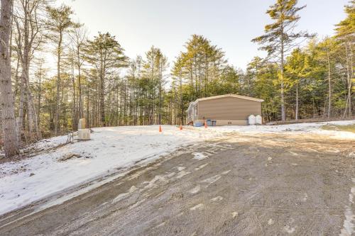 a dirt road with a building in the woods at Less Than 1 Mi to Beach Peaceful Brant Lake Home! in Brant Lake