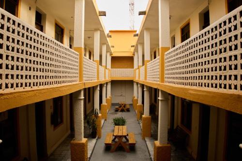 un couloir vide d'un bâtiment avec des tables et des bancs dans l'établissement Hotel San Lorenzo, à Barra de Navidad