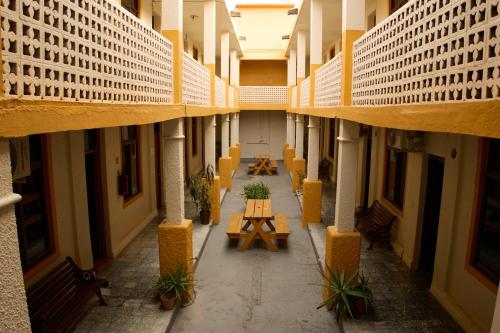 an empty hallway of a building with tables and benches at Hotel San Lorenzo in Barra de Navidad