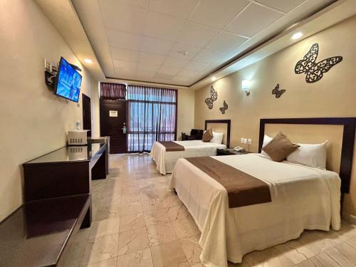 a hotel room with two beds and a television at Hotel Yorio Inn in Tuxpan de Rodríguez Cano
