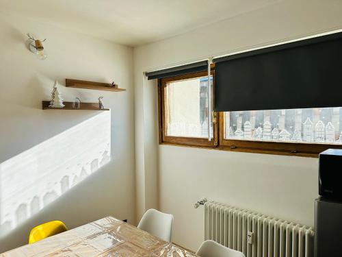 a dining room with a table and a window at Casa Amanda in Sestriere