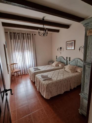 厄爾巴拉克的住宿－Casas Rurales TIO CLAUDIO I y II，一间卧室配有两张床和椅子