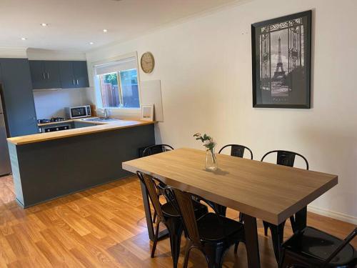 cocina y comedor con mesa y sillas en Beautiful 3BR Home by Dandenong Creek, en Bayswater