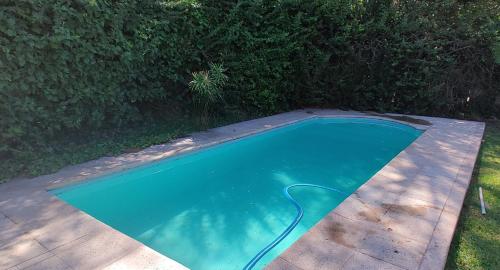 una pequeña piscina con una manguera en un patio en Posada del. Huerto en Luján de Cuyo