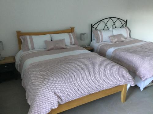 2 nebeneinander sitzende Betten in einem Schlafzimmer in der Unterkunft Cosy Cottage Broadford in Broadford