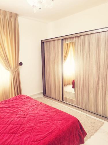 una camera con un grande letto e un grande specchio di Great apartment with great location ad Amman
