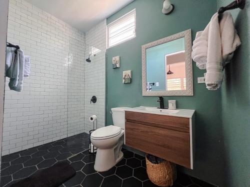 a bathroom with a toilet and a sink and a mirror at Dream Beach House by Sonsoleá Host in Luquillo