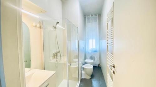 a white bathroom with a shower and a toilet at Miraflowers Home in Turin