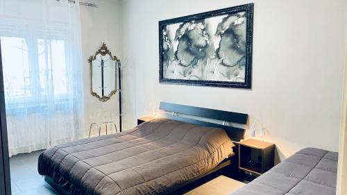 a bedroom with a bed and a picture on the wall at Miraflowers Home in Turin