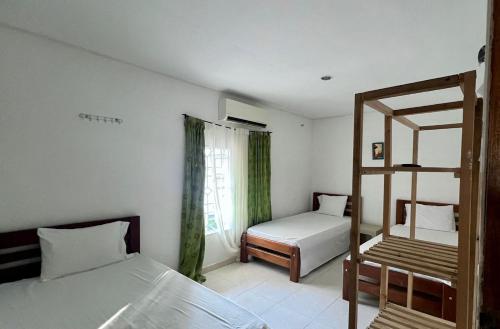 a bedroom with two beds and a window and a ladder at Finca Hotel Villa Manuela in Sahagún