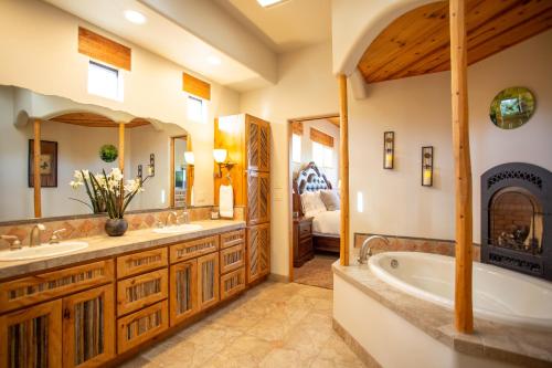 ein Badezimmer mit zwei Waschbecken und einer Badewanne sowie ein Schlafzimmer in der Unterkunft Spectacular Sedona Destination with Pool & Spa in Sedona