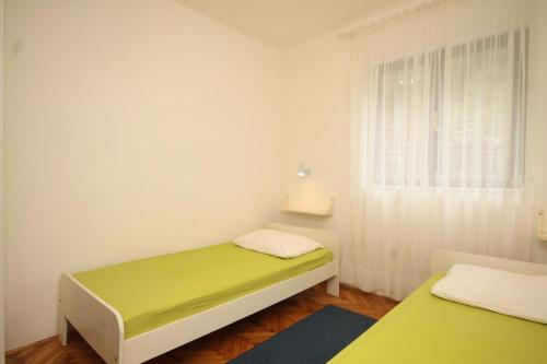 a small room with two beds and a window at Apartments by the sea Lukoran (Ugljan) - 8494 in Lukoran