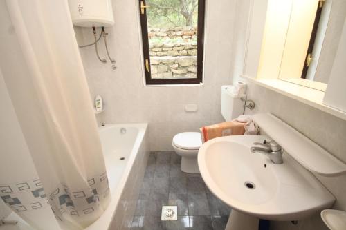 a white bathroom with a sink and a toilet at Apartments by the sea Lukoran (Ugljan) - 8494 in Lukoran