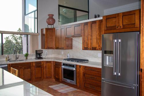 a kitchen with wooden cabinets and a stainless steel refrigerator at Open Style Home with Magnificent Views! in Sedona