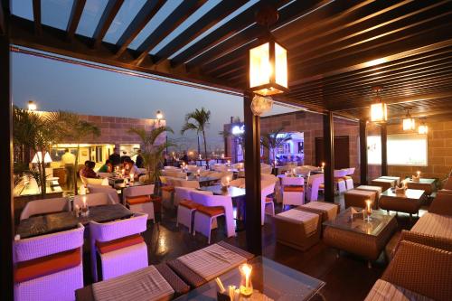 a restaurant with purple lighting and tables and chairs at The Lindsay in Kolkata