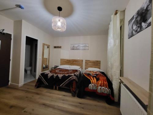 een slaapkamer met een bed en een kroonluchter bij HOTEL IN PARIS in Aubervilliers