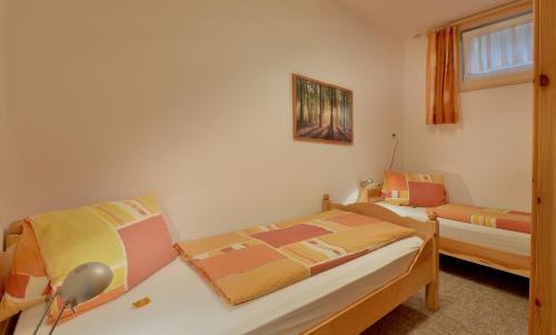 sypialnia z 2 łóżkami i oknem w obiekcie Ferienwohnung Seethaler w mieście Thiersee