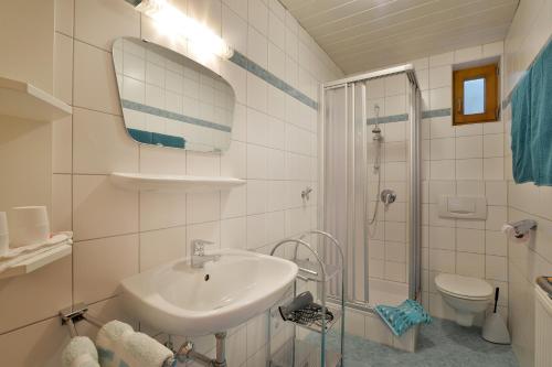 a white bathroom with a sink and a shower at Ferienwohnung Seethaler in Thiersee