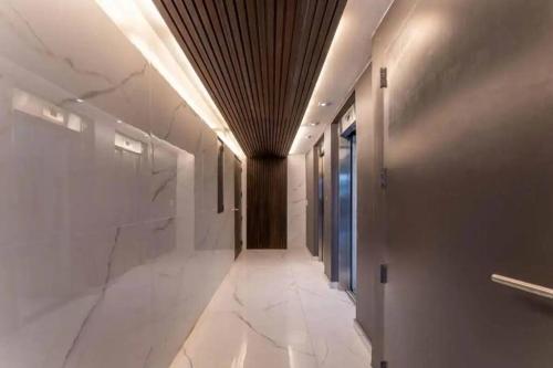 - un couloir avec un sol en marbre blanc et un plafond dans l'établissement Lujoso Penthouse a estrenar en Sofisticado Barrio y Edificio Vista panorámica 100m2 Gimnasio Piscina Lujoso Salon de Fiestas Parking privado con acceso directo al departamento, à Buenos Aires